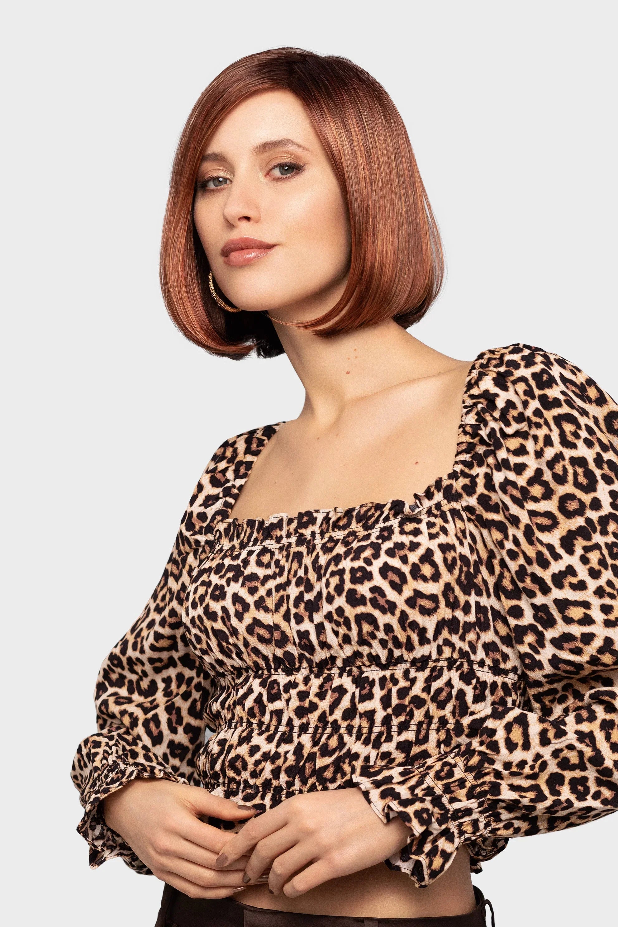 Next wig by Gisela Mayer, side view showing the mid-length angled bob with side piece and sleek synthetic style.