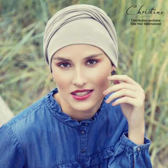 Ce bonnet préformé Viva Headwear, doublé avec un bandeau croisé, offre style et confort tout en masquant efficacement une pelade.