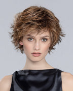 A woman wearing the Date Large short wig with a modern layered and tapered cut in a tousled style by Ellen Wille.