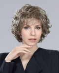 A woman showcasing the Ellen Wille Alexis wig, featuring elegant delicate waves and a sophisticated urban cut with natural volume.