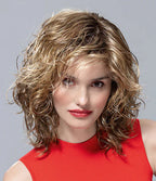 A woman modeling the Ellen Wille Beach Mono wig, showcasing its mid-length beach waves, casual curls, and natural volume.