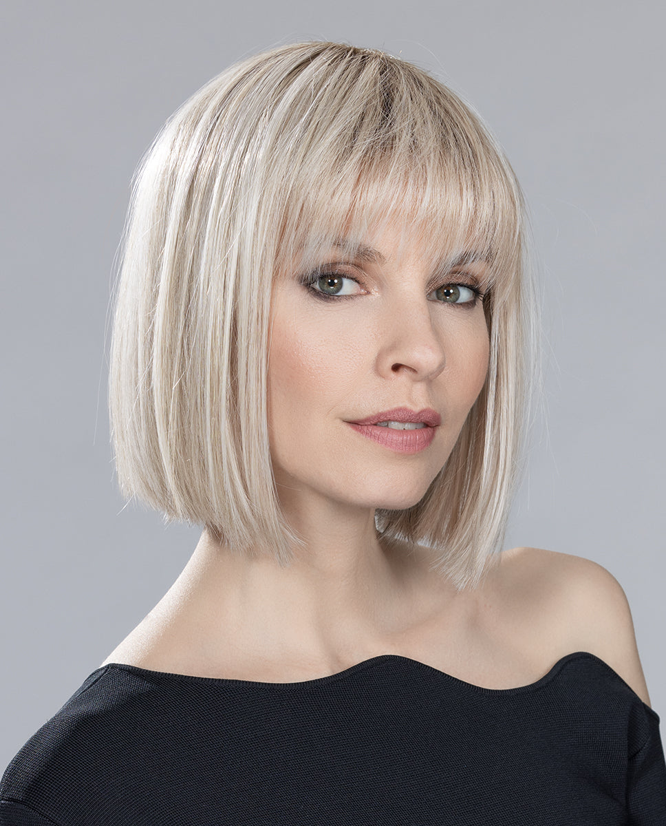 Front view of a woman wearing the Ellen Wille Cleo mid-length wig, showcasing its sharp blunt bob cut and thick, full fringe.