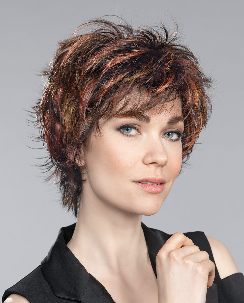 A woman modeling the Ellen Wille Click short wig, highlighting its modern tapered pixie cut and dynamic textured styling.