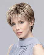 A woman wearing the sophisticated Ellen Wille Estate Mono pixie wig, highlighting its realistic monofilament top, extended lace front hairline, and sleek gray color.