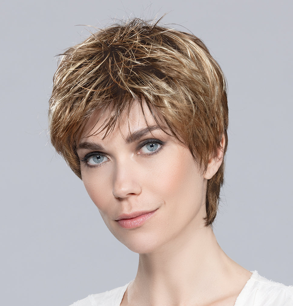 Profile view of a woman wearing the Ellen Wille Fair short wig, showcasing its sporty tapered neckline and elegant wispy fringe.