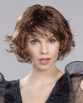 A woman modeling the Ellen Wille Flair Mono wig, showcasing its gently waved bob silhouette, natural monofilament parting, and invisible extended lace front.