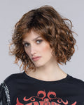 A woman modeling the Ellen Wille Girl Mono Part wig, showcasing its textured mid-length waves, natural parting line, and voluminous, bold silhouette.