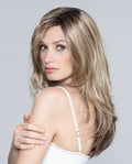 A woman modeling the long Glamour Mono Part wig by Ellen Wille, showcasing its sleek cascading layers, natural volume, and realistic parting.