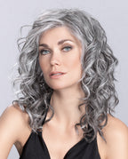 A woman modeling the long, flowing Ellen Wille Heaven Mono Part wig, showcasing its ultra-natural parting line, polished length, and feminine layers.