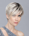 A woman modeling the short Ellen Wille Jump Mono wig, showcasing its modern asymmetrical side volume and seamless monofilament top parting.