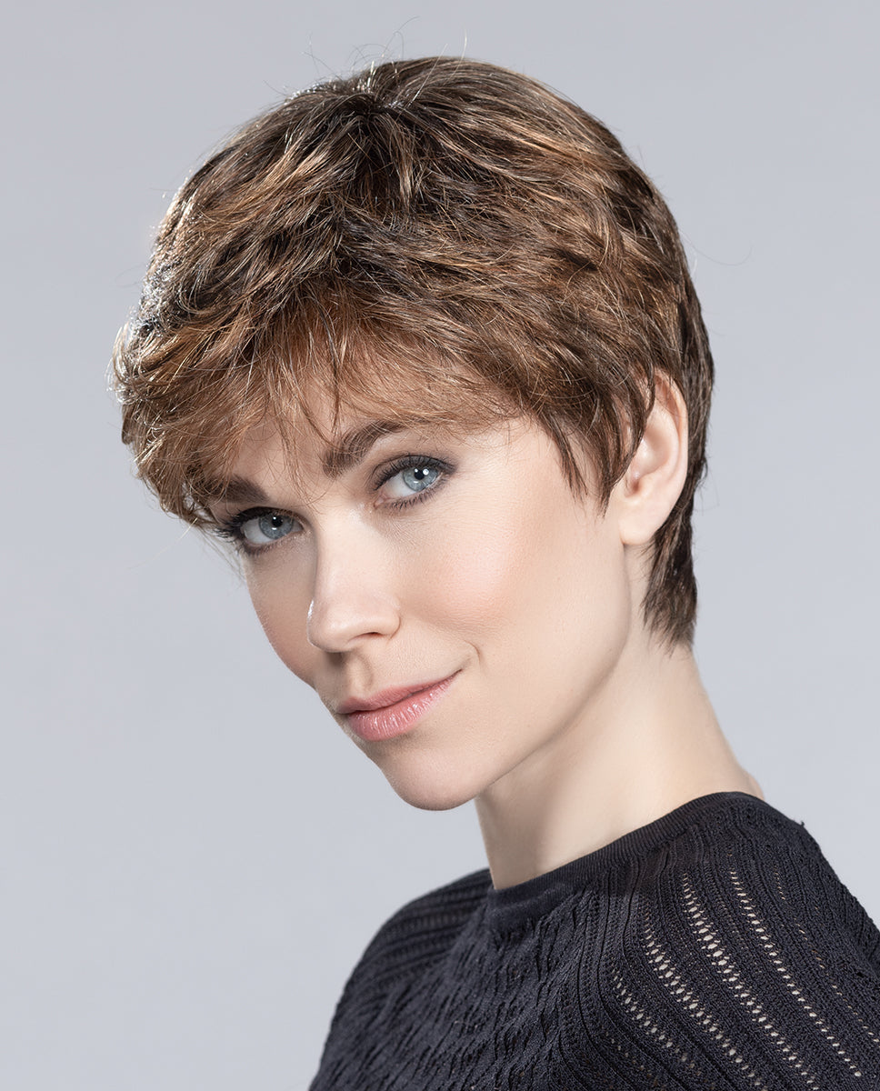A woman modeling the short Ellen Wille Mia Mono wig, showcasing its dynamic tapered crown layers, natural volume, and seamless monofilament top.