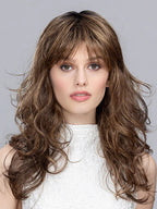 Front view of a woman modeling the Ellen Wille Pretty wig, highlighting its elegant shoulder-length waves, voluminous shape, and classic straight fringe.