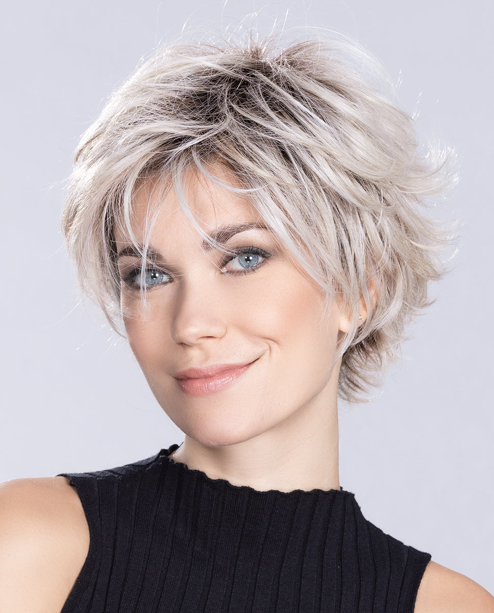 A woman modeling the Ellen Wille Relax Large short wig, highlighting its comfortable large cap fit, texturized tapered layers, and natural fluid movement.