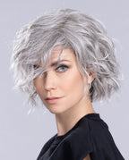 Front view of a woman modeling the Ellen Wille Scala wig, highlighting its textured short wavy bob layers, invisible extended lace front, and natural parting.