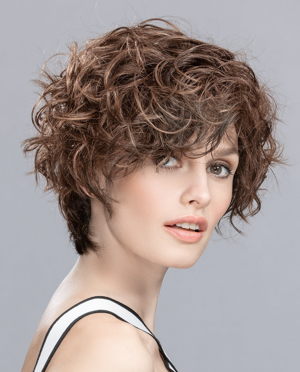 Front view of a woman modeling the Ellen Wille Show wig, showcasing its impressive volume, elongated wavy side length, and elegant face-framing layers.