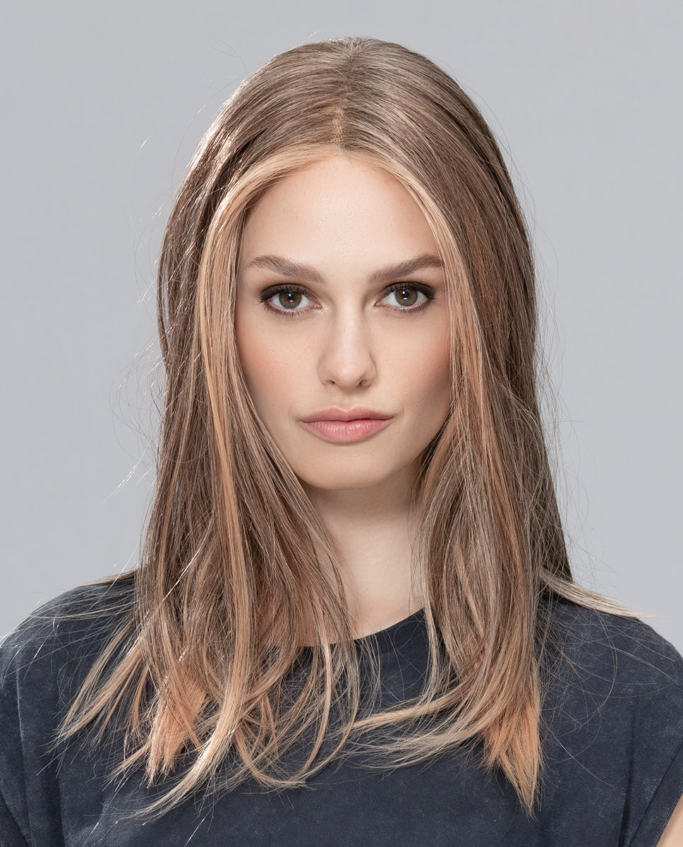 A woman modeling the long Ellen Wille Sleek Mono Part wig, showcasing its smooth straight length past the shoulders, subtle layered tips, and natural scalp parting.
