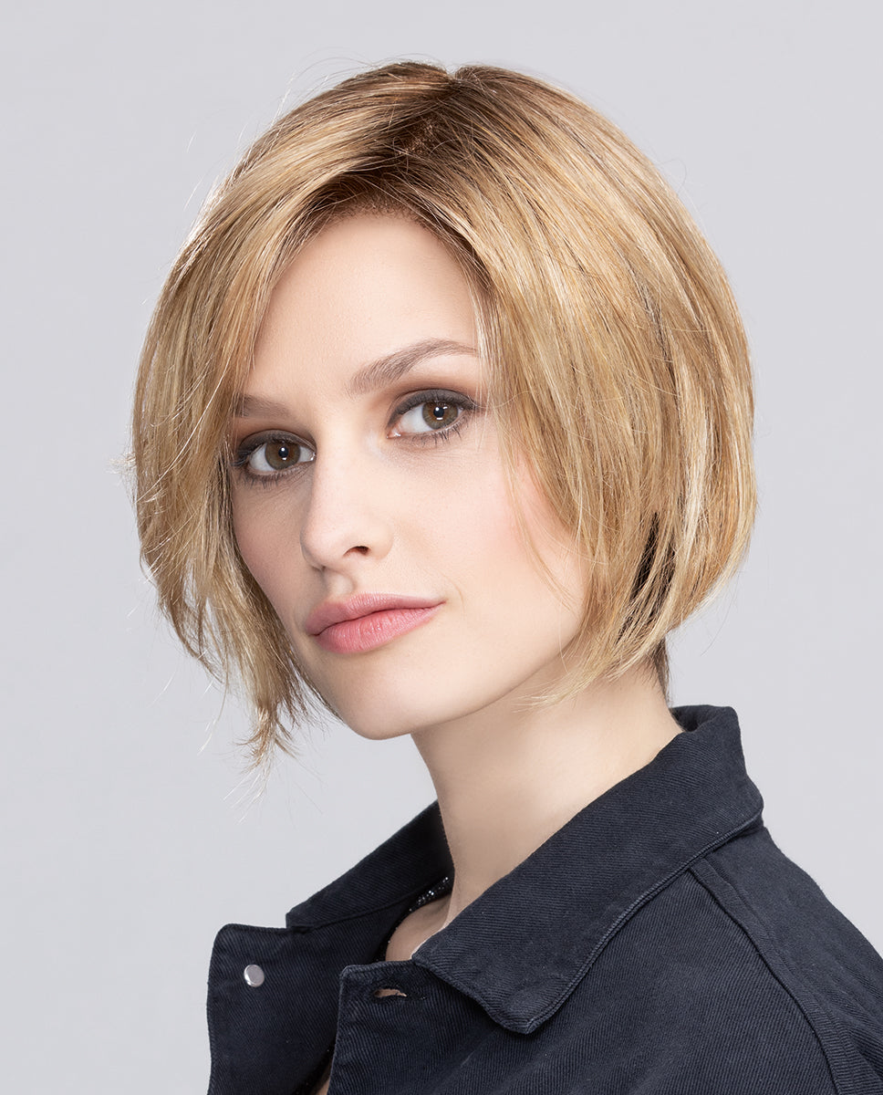 Side profile of a woman modeling the Ellen Wille Talia Mono wig, showcasing its short contemporary bob cut, clean tapered nape, and sweeping side fringe.