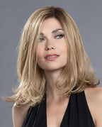 Front view of a woman modeling the long Ellen Wille Taste Mono Part wig, showcasing its below-the-shoulder layers, natural scalp parting, and soft movement.