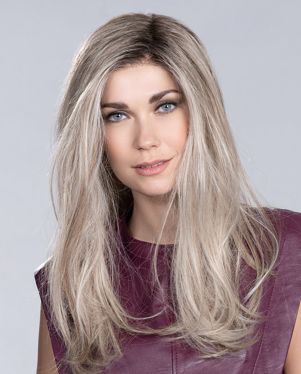 A woman modeling the long, layered Ellen Wille Vita wig, showcasing its smooth texture, impressive length, and seamless extended lace front hairline.