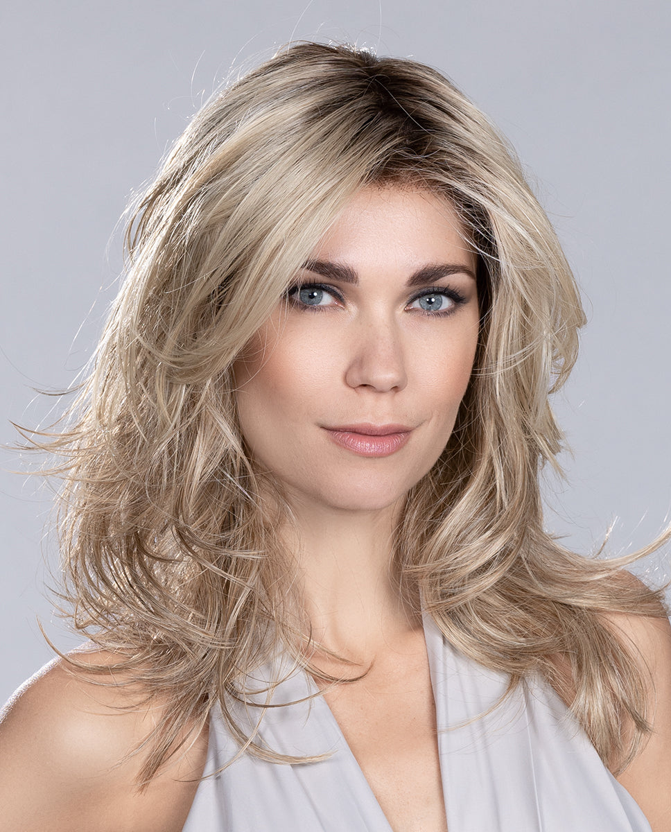 Front view of a woman modeling the long Ellen Wille Voice wig, showcasing its playful tapered layers, invisible lace front hairline, and natural monofilament parting.