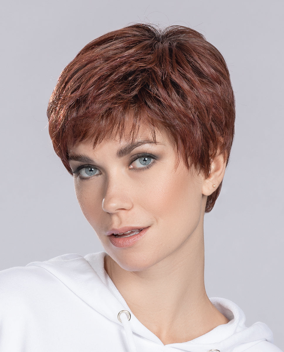 A woman modeling the Ellen Wille Yoko short wig, showcasing its classic cropped layers, versatile styling, and natural texture.