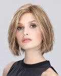 A woman modeling the Ellen Wille Young Mono Part wig, showcasing its texturized mid-length straight bob cut, versatile lace front hairline, and natural scalp parting.